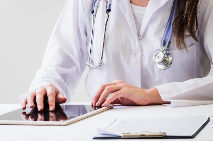 primer-plano-doctora-usando-tableta-digital-e-informe-medico-escritorio_23-2148129593